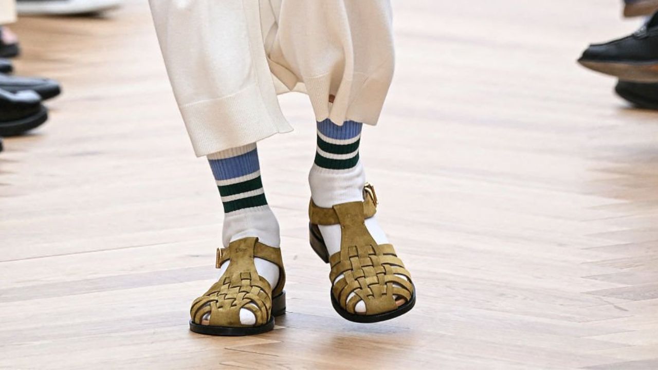 Jonathan Anderson reinventa o styling masculino na Dior Men com alfaiataria, sandália e meia.